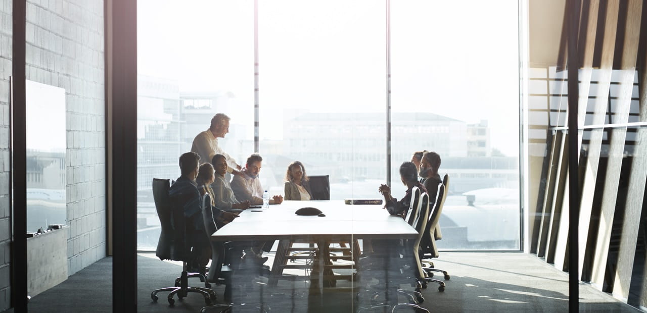 Business owner and employees meet in a modern conference room to discuss corporate philanthropy and how a donor-advised fund can streamline and enhance their charitable giving strategy.