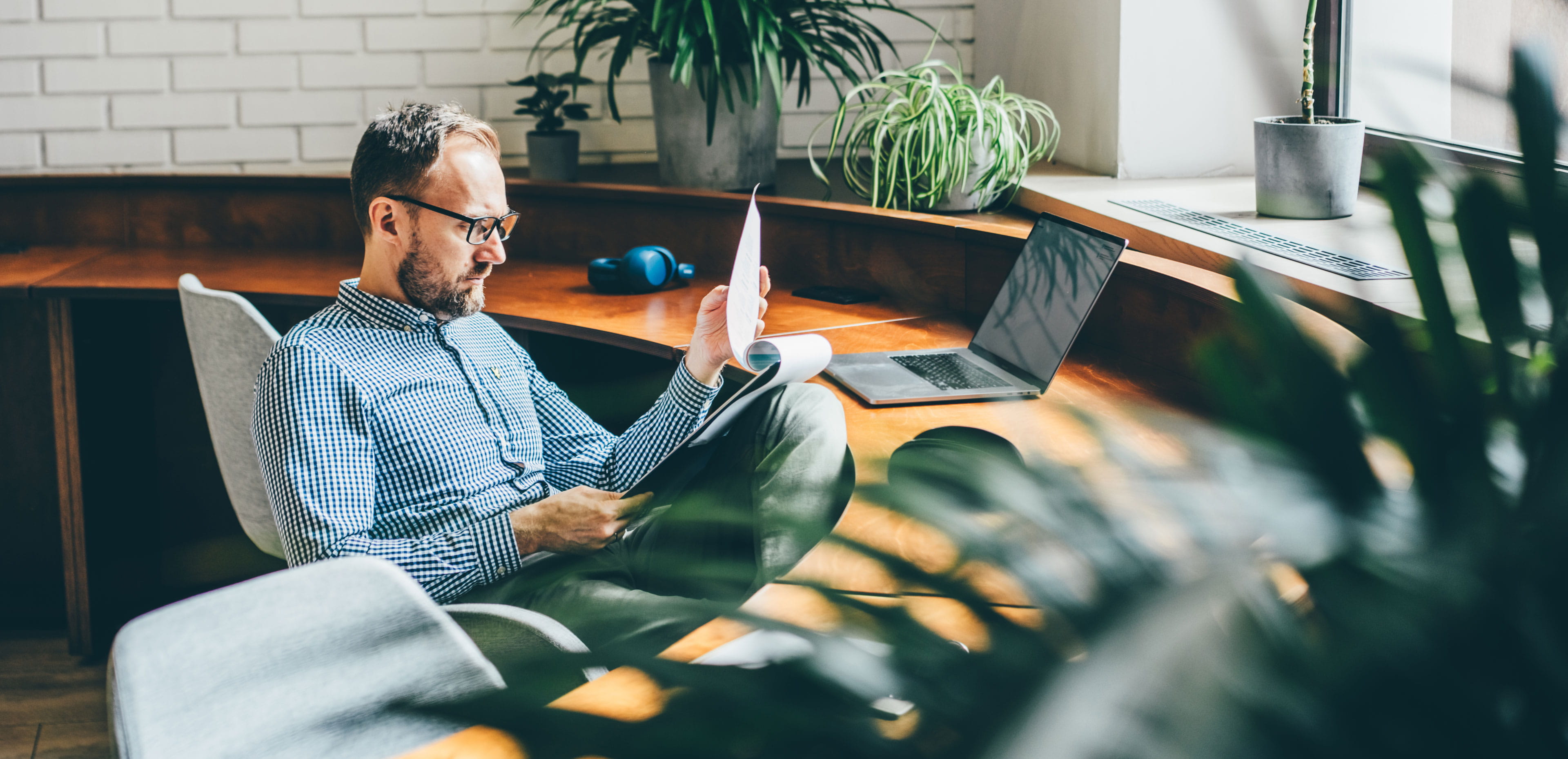 Person reviews financial documents at a desk, representing how active ETFs can simplify investing by providing diversified exposure through a single investment.