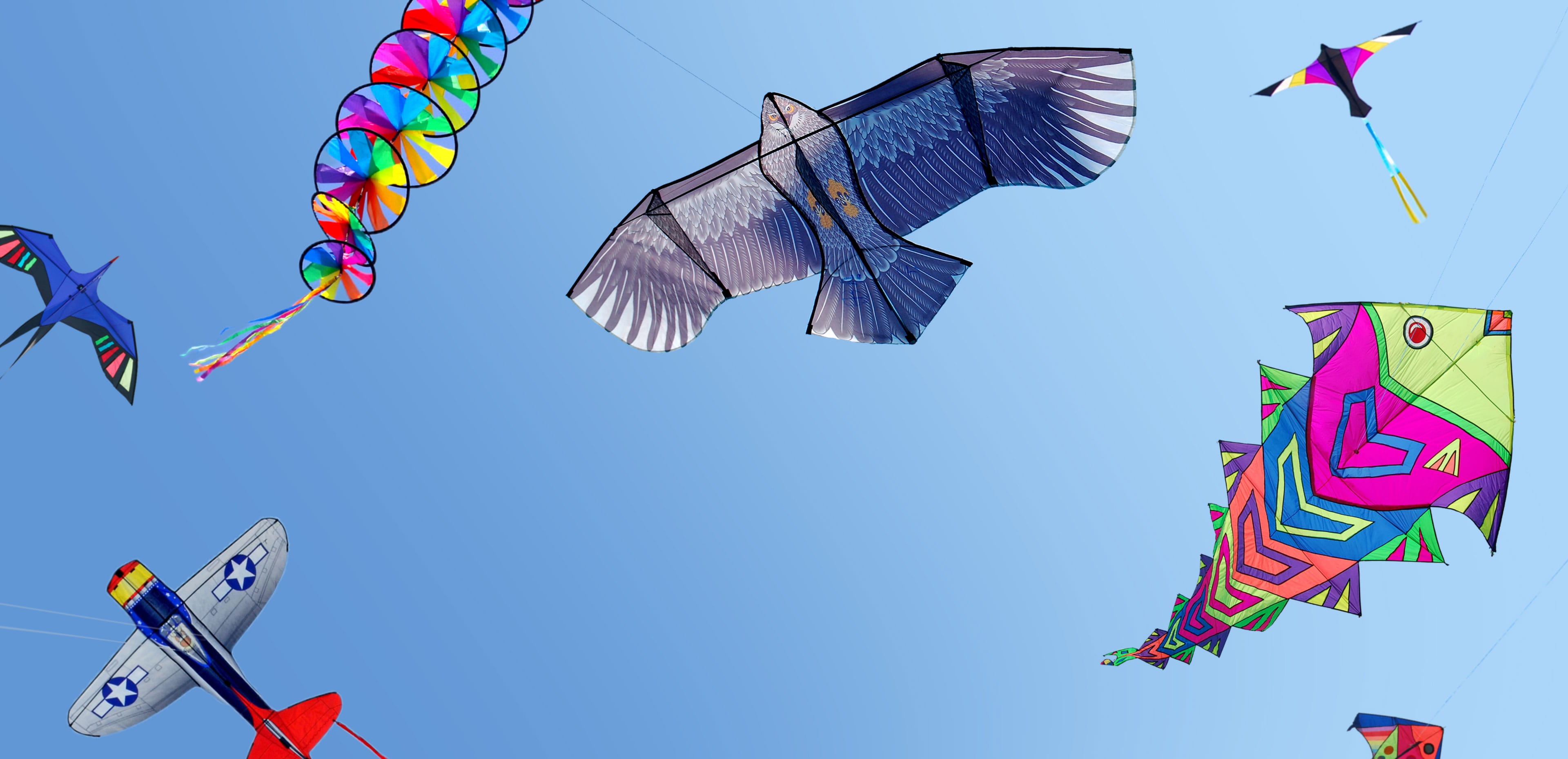 Colorful kites soar across a bright blue sky, symbolizing how embracing playful, childlike activities can support emotional, mental, and physical well-being in adulthood.