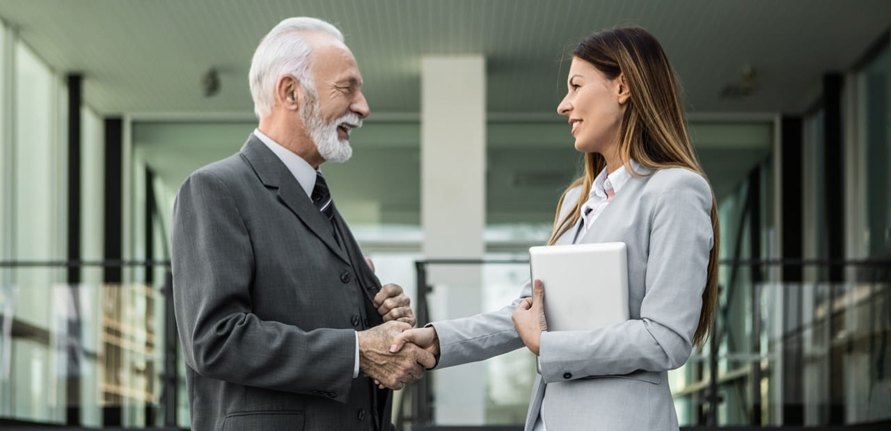 Business owner shaking hands with an advisor, representing planning an estate plan to protect and transfer a business.