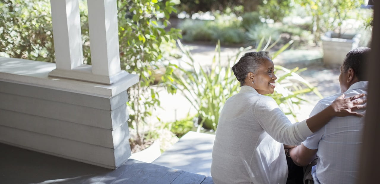 Retired couple sitting together on a porch, representing support and stability through Social Security survivor benefits.
