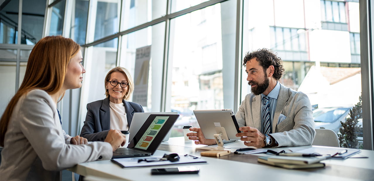 Business people having meeting using digital tablet and laptop in modern office