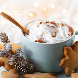 Cup of hot chocolate with marshmallows on christmas themed table